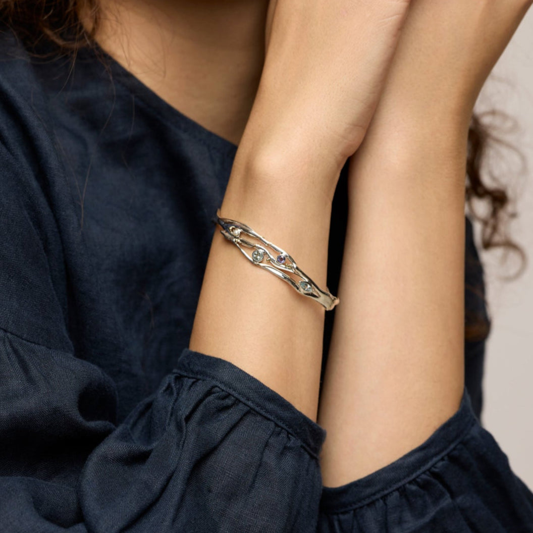 Woman wearing a bracelet with a neutral background