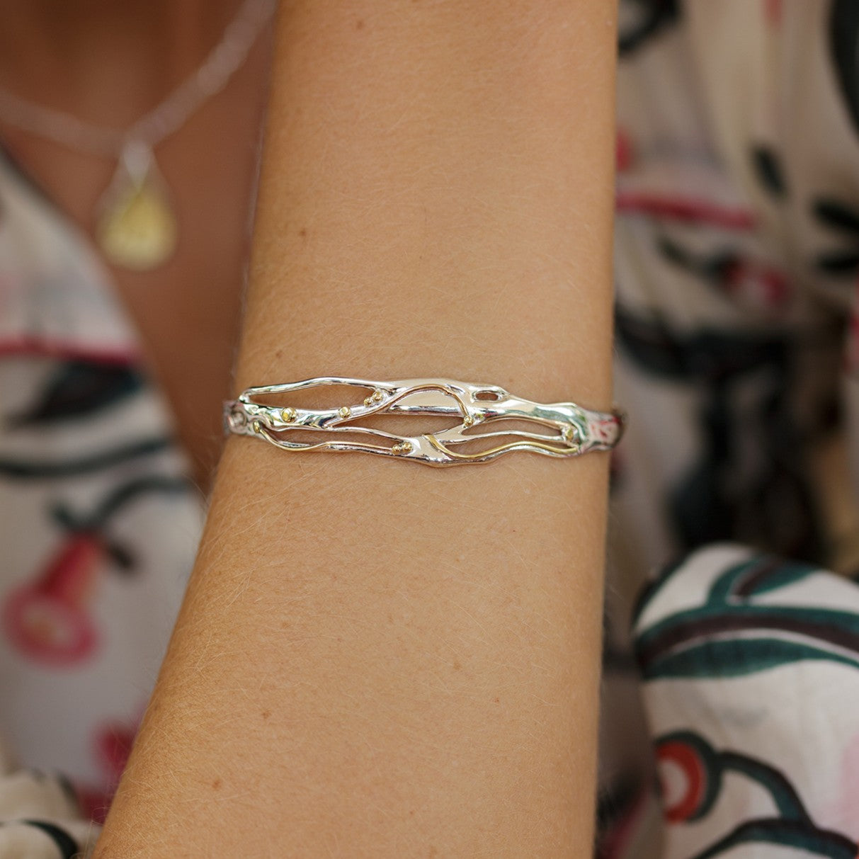 mixed metal bracelet worn on model's wrist