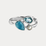 Silver ring with blue gemstones on a white background
