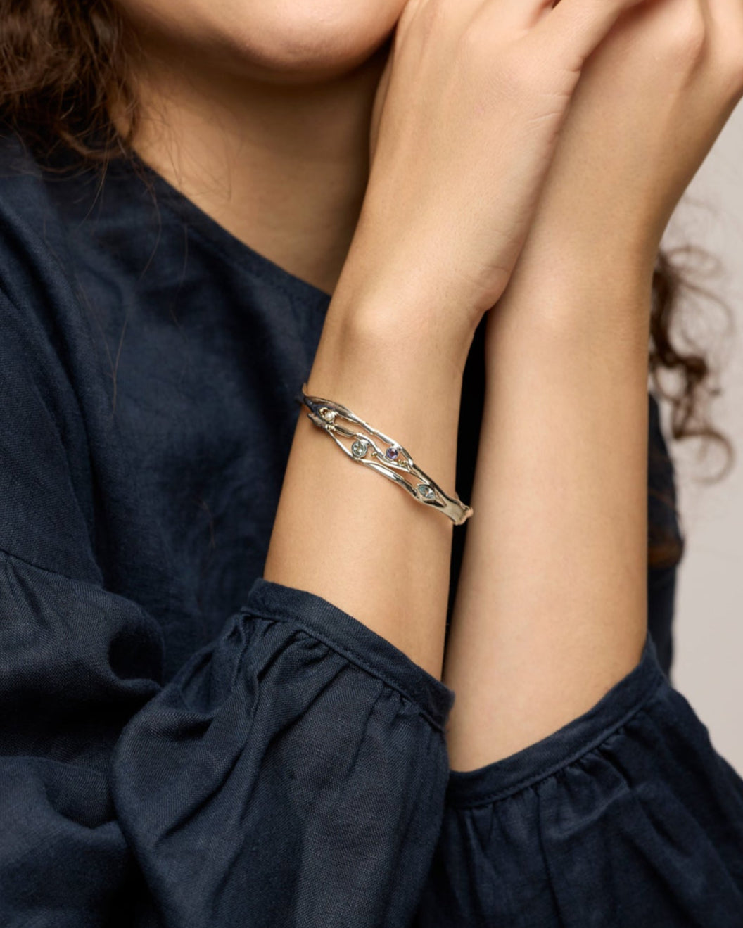 Woman wearing a bracelet with a neutral background
