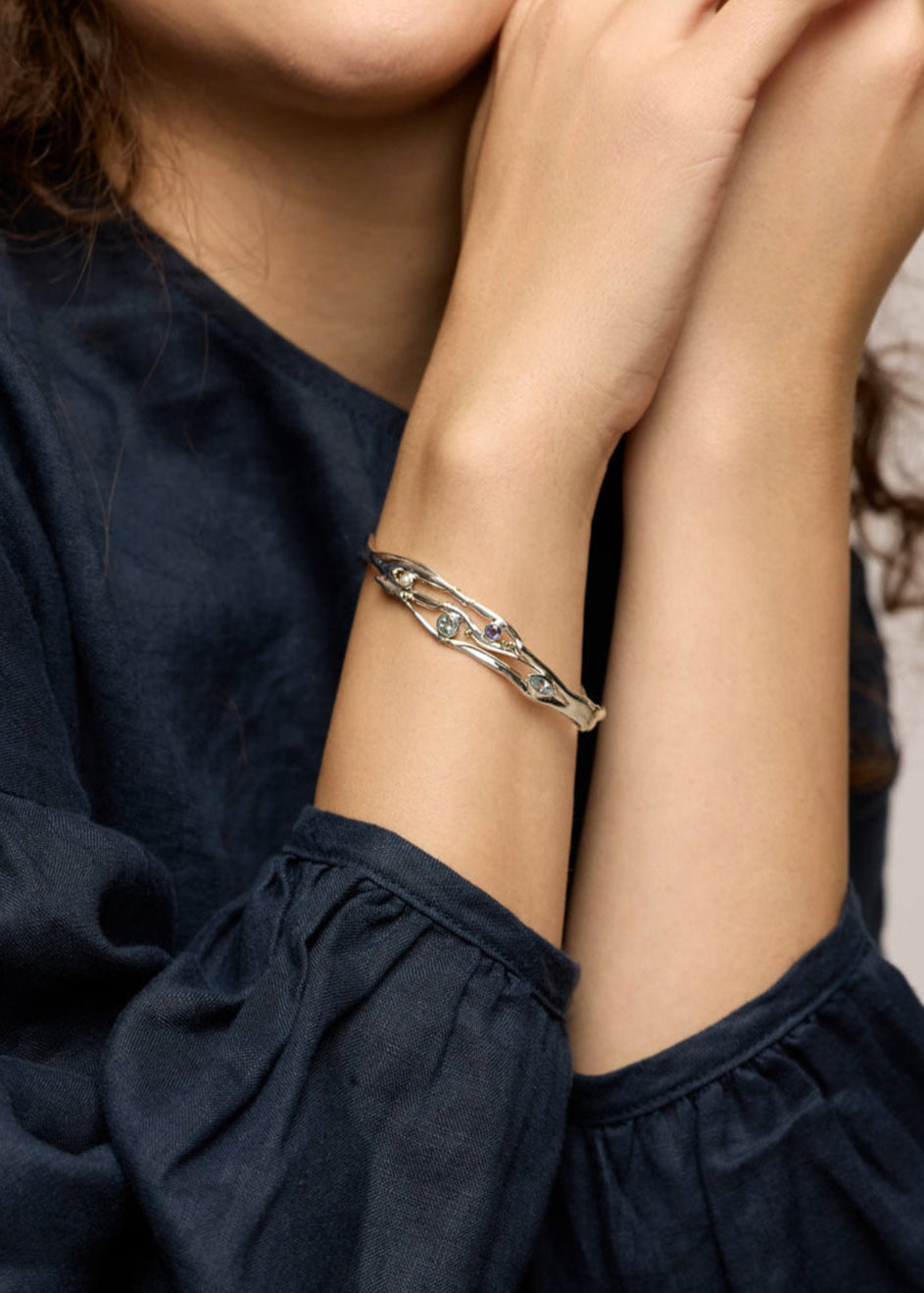 Woman wearing a bracelet with a neutral background