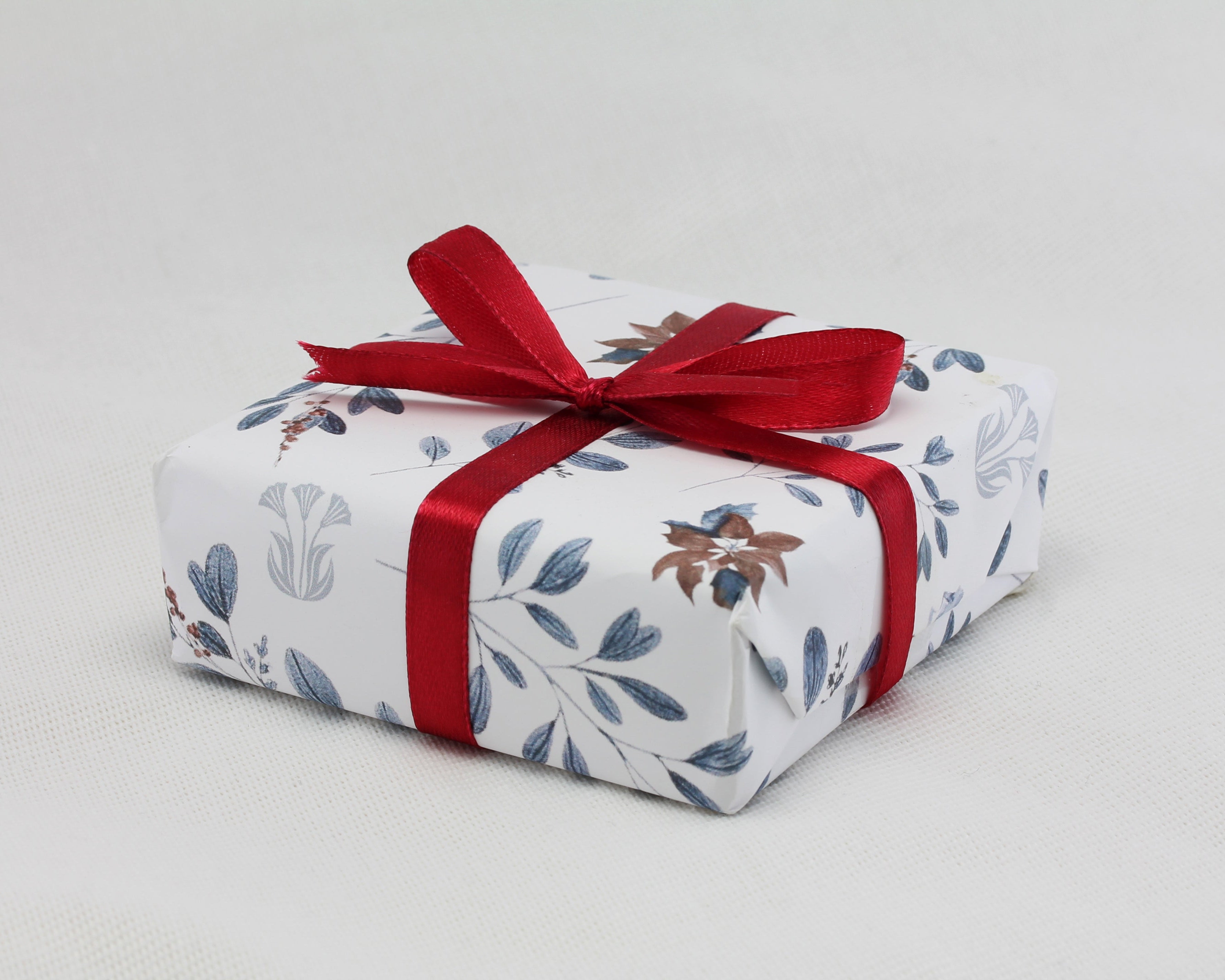 A jewellery box is beautiful wrapped with Isla Silver's signature Christmas wrapping paper and finished with a red ribbon.