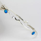 Silver bracelet with blue Opal stones on a white background