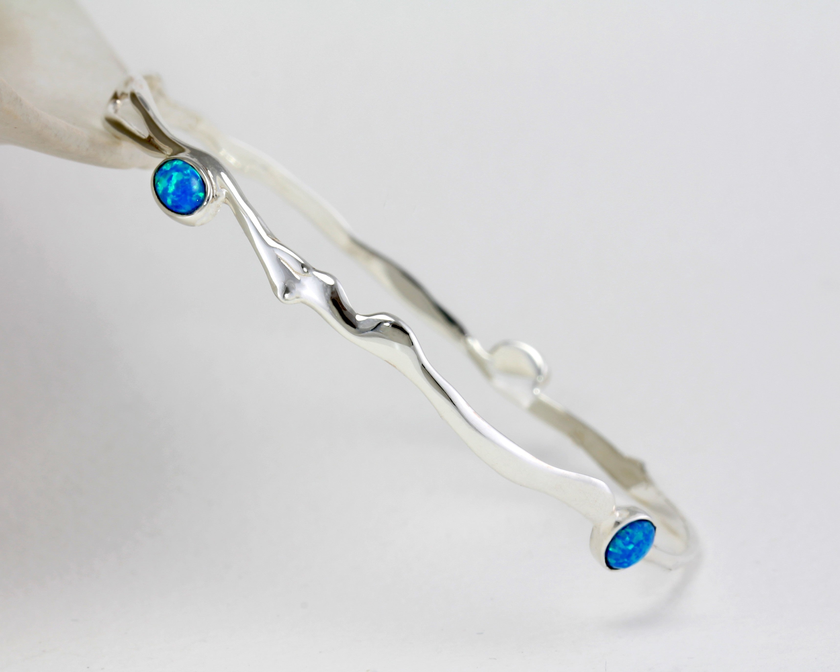 Silver bracelet with blue Opal stones on a white background