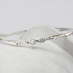 Silver bracelet with pearl and opalite stone on a white background
