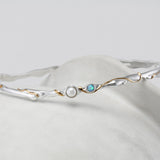 Silver bracelet with pearl and opalite stone on a white background