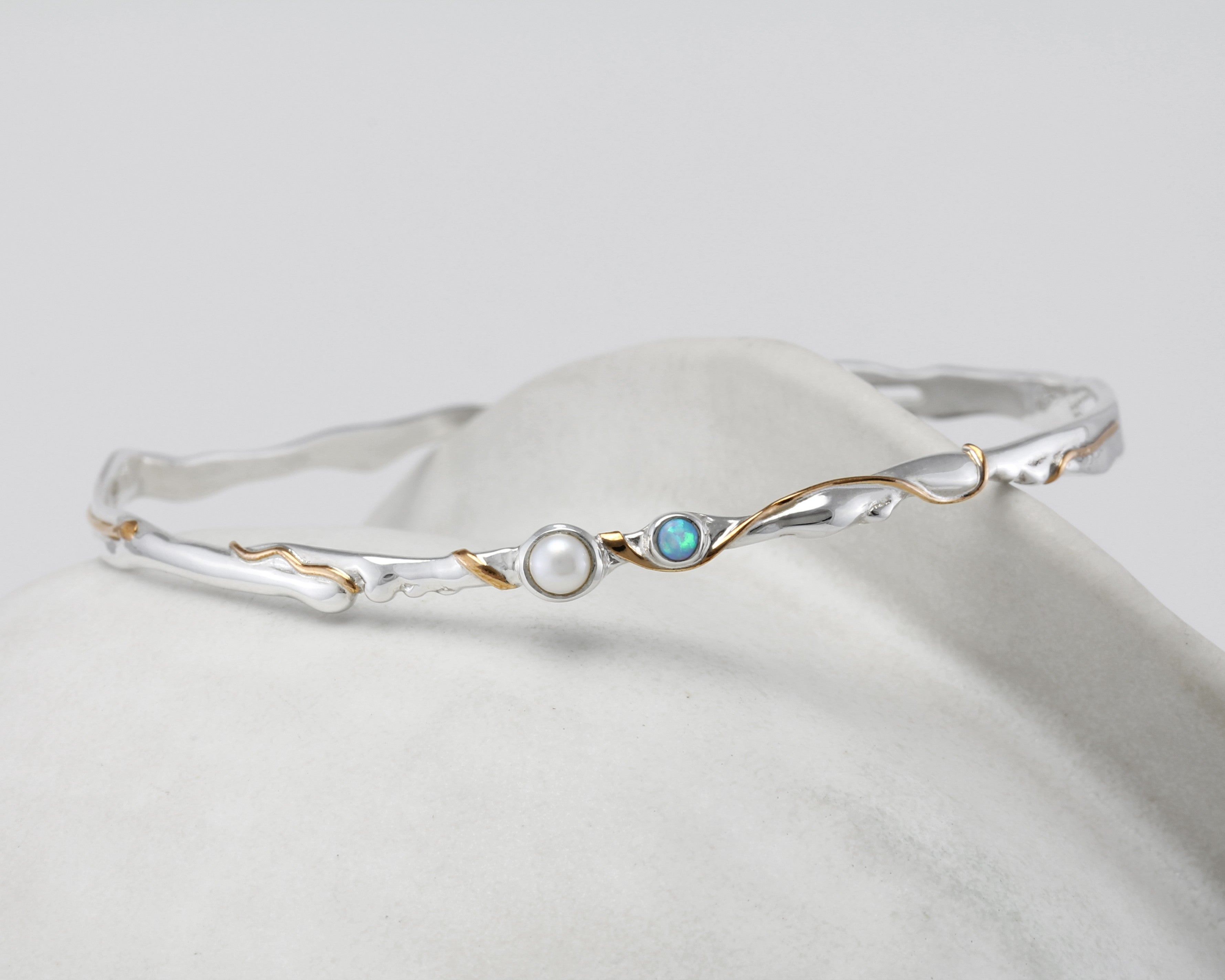 Silver bracelet with pearl and opalite stone on a white background