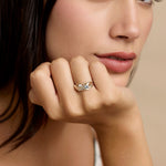 Model wearing silver ring with blue topaz and pearl stones