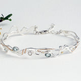 hinged bracelet with blue topaz and pearl crafted from sterling silver