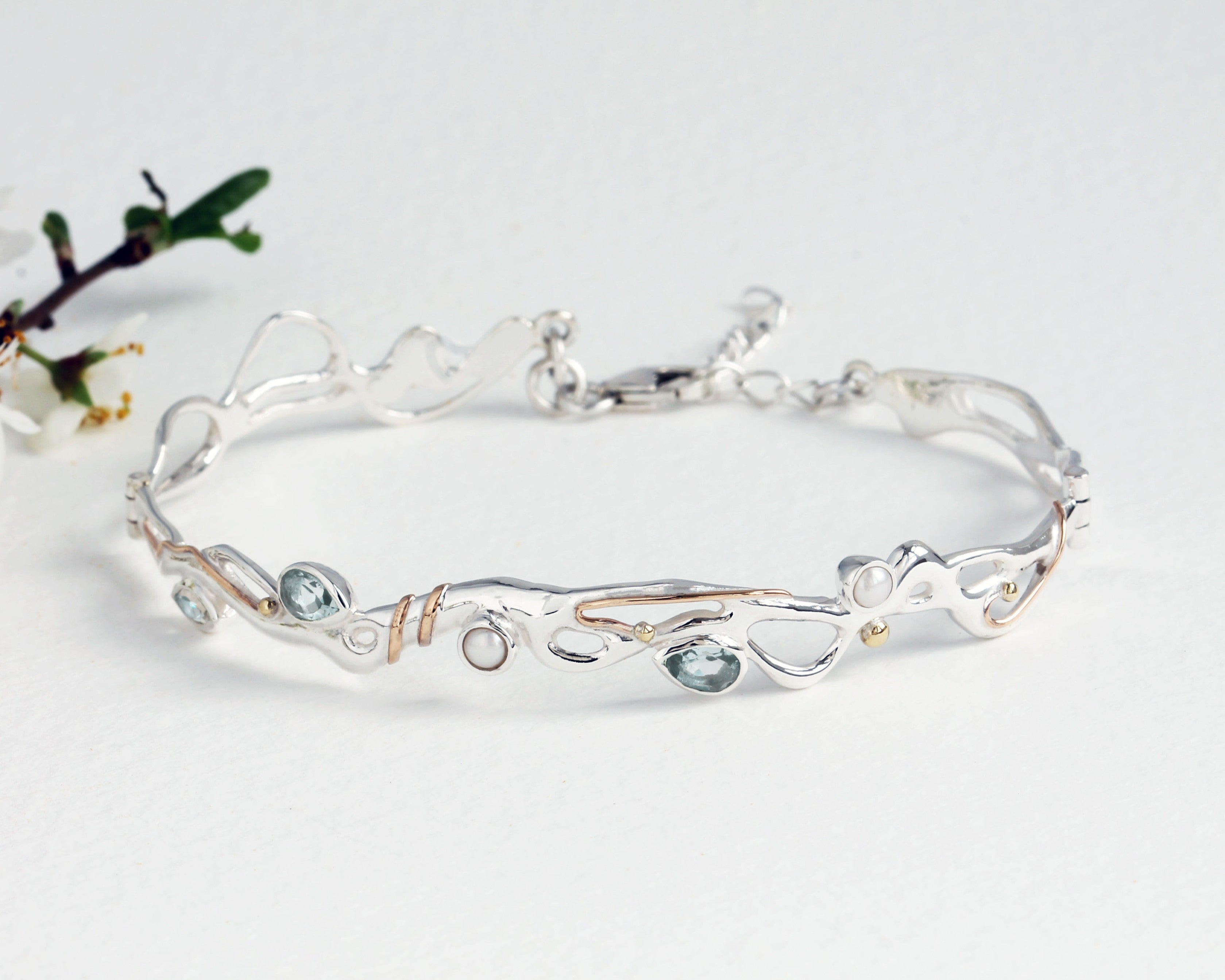 hinged bracelet with blue topaz and pearl crafted from sterling silver