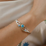 Silver bracelet with blue stones on a wrist with summer clothes