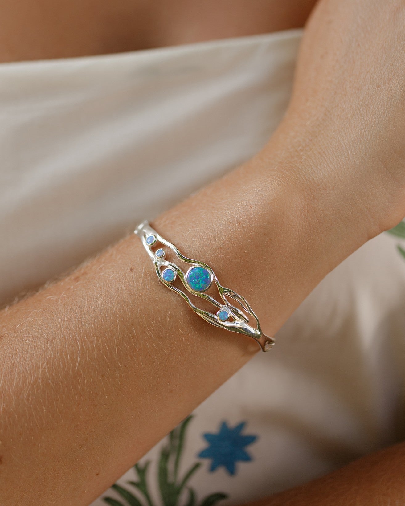 Silver bracelet with blue stones on a wrist with summer clothes