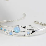 Silver bracelet with blue gemstones on a white background with chain and lobster clasp