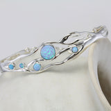 Sterling silver bracelet with five round blue Opals balanced on a pot