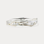 A handmade sterling silver bangle bracelet with moonstone and 14KT gold details, displayed against a white background.