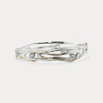 A Sterling Silver bangle featuring round Blue Topaz and a Freshwater Pearl, with 14KT Gold detailing.