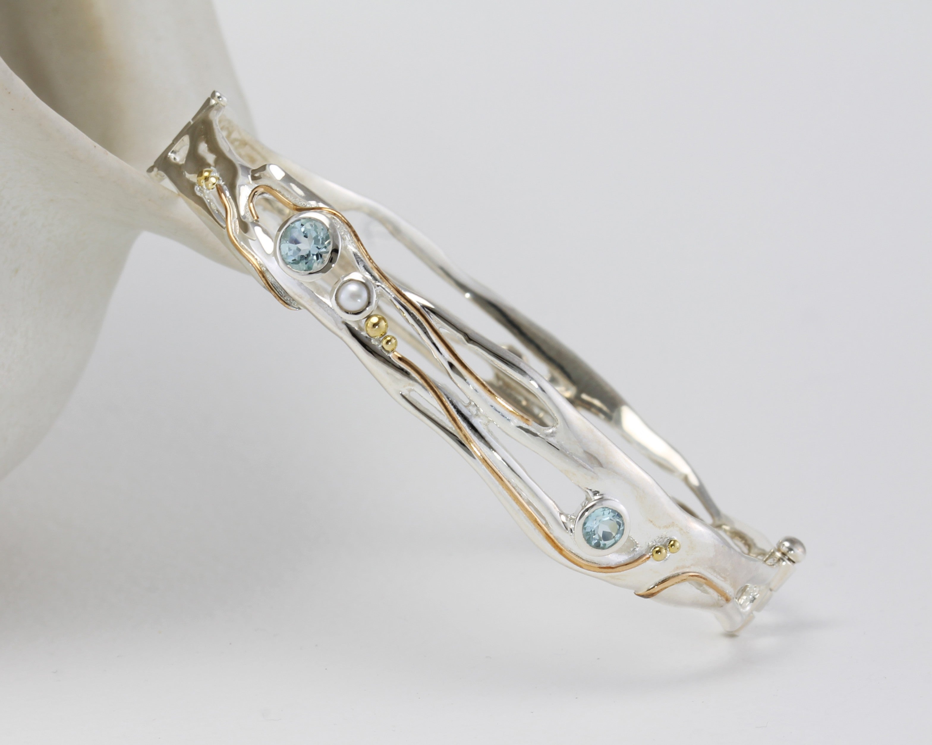 sterling silver bangle with blue topaz, pearl and gold details