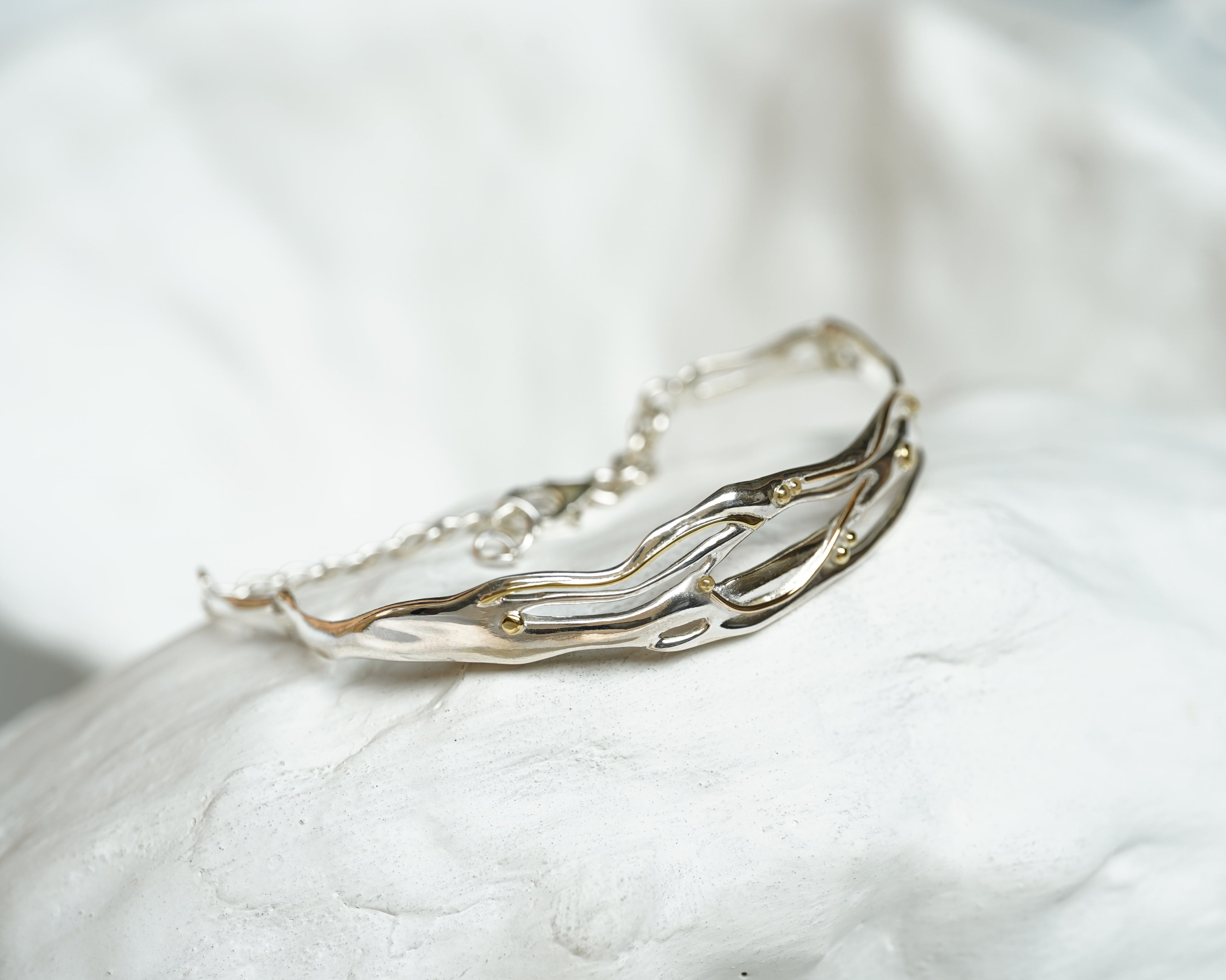 Silver bracelet on a white stone surface