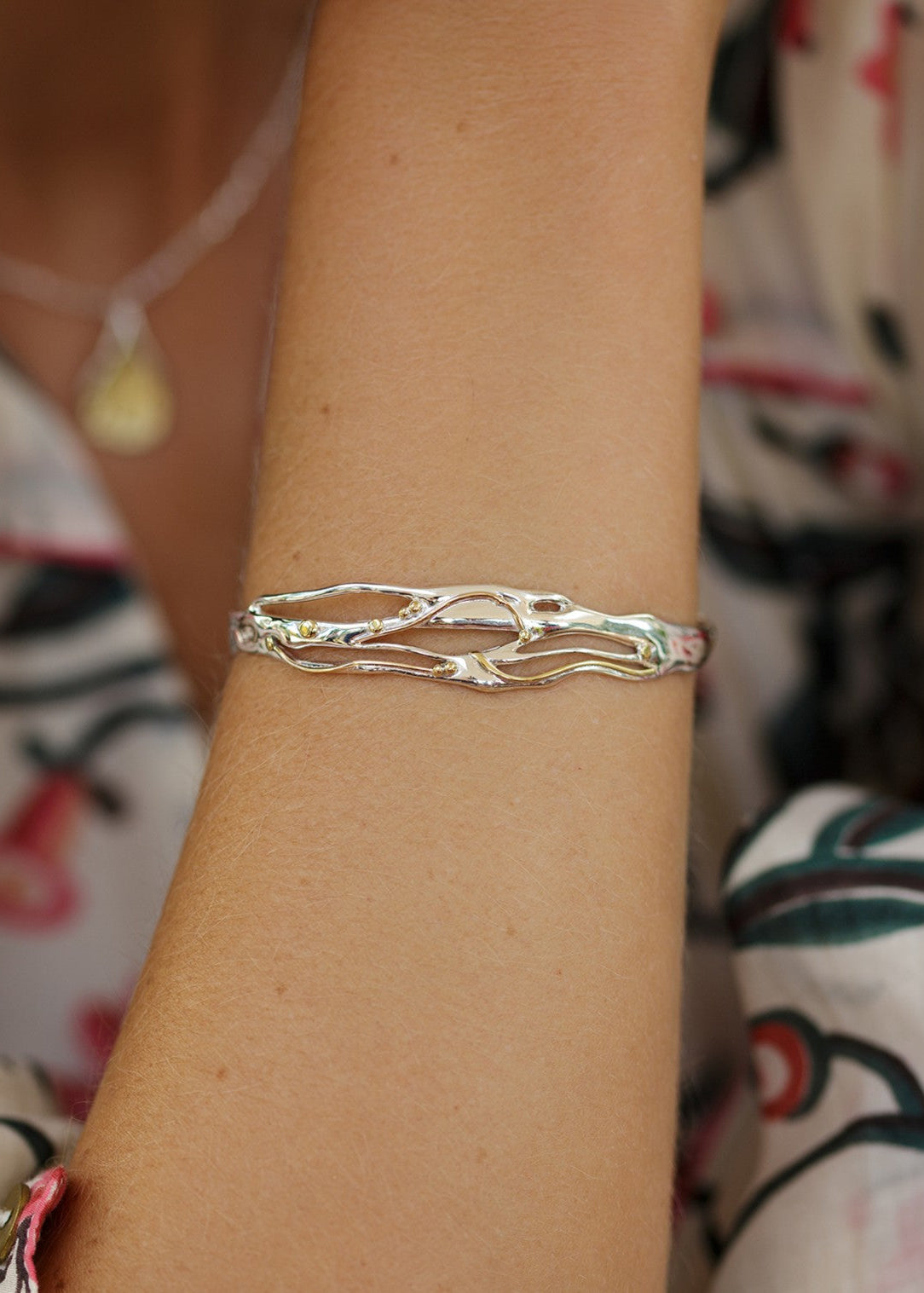mixed metal bracelet worn on model's wrist