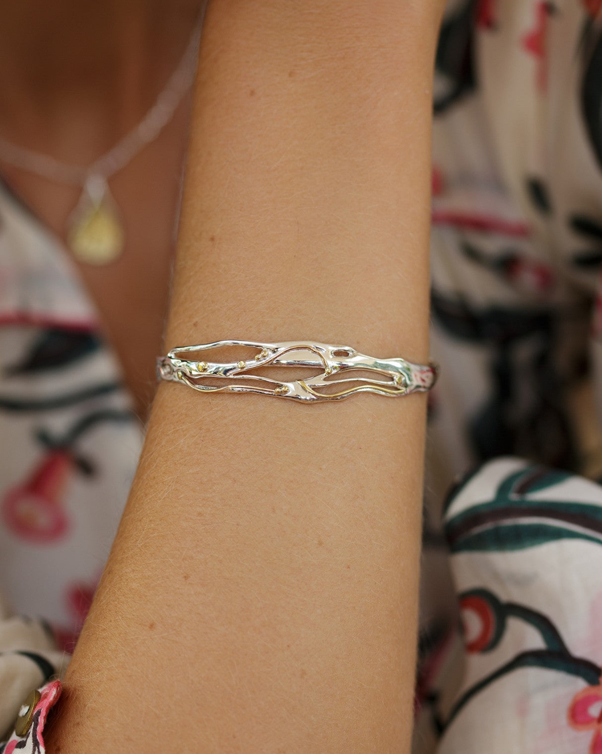 mixed metal bracelet worn on model's wrist