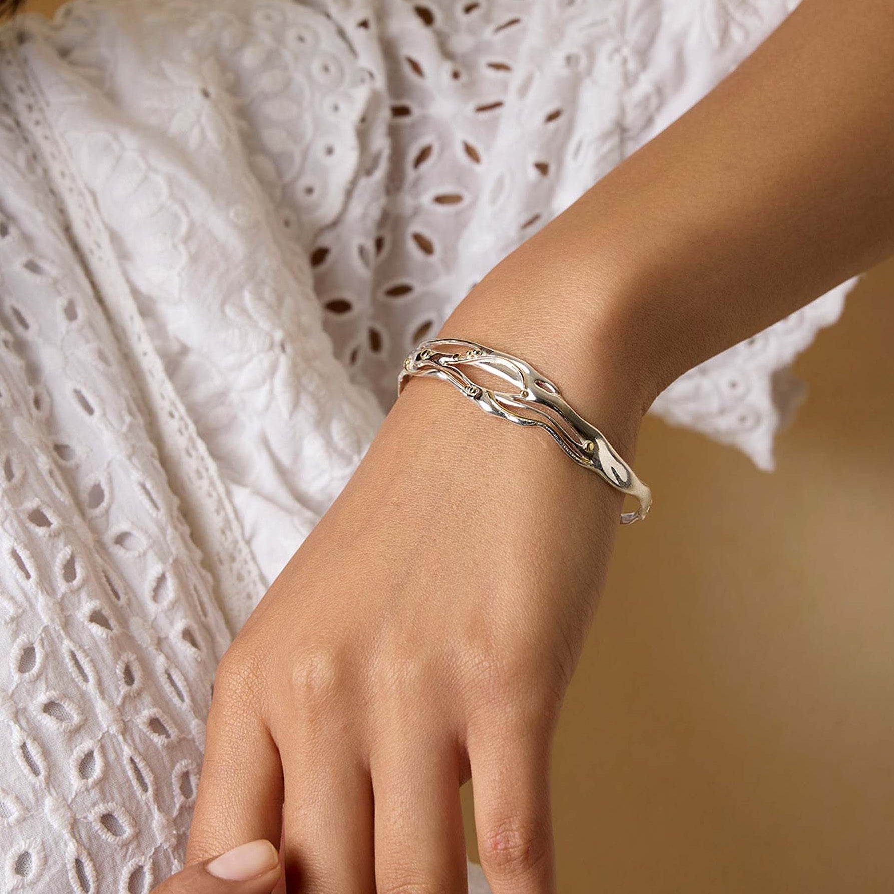 model wearing a silver and gold bracelet