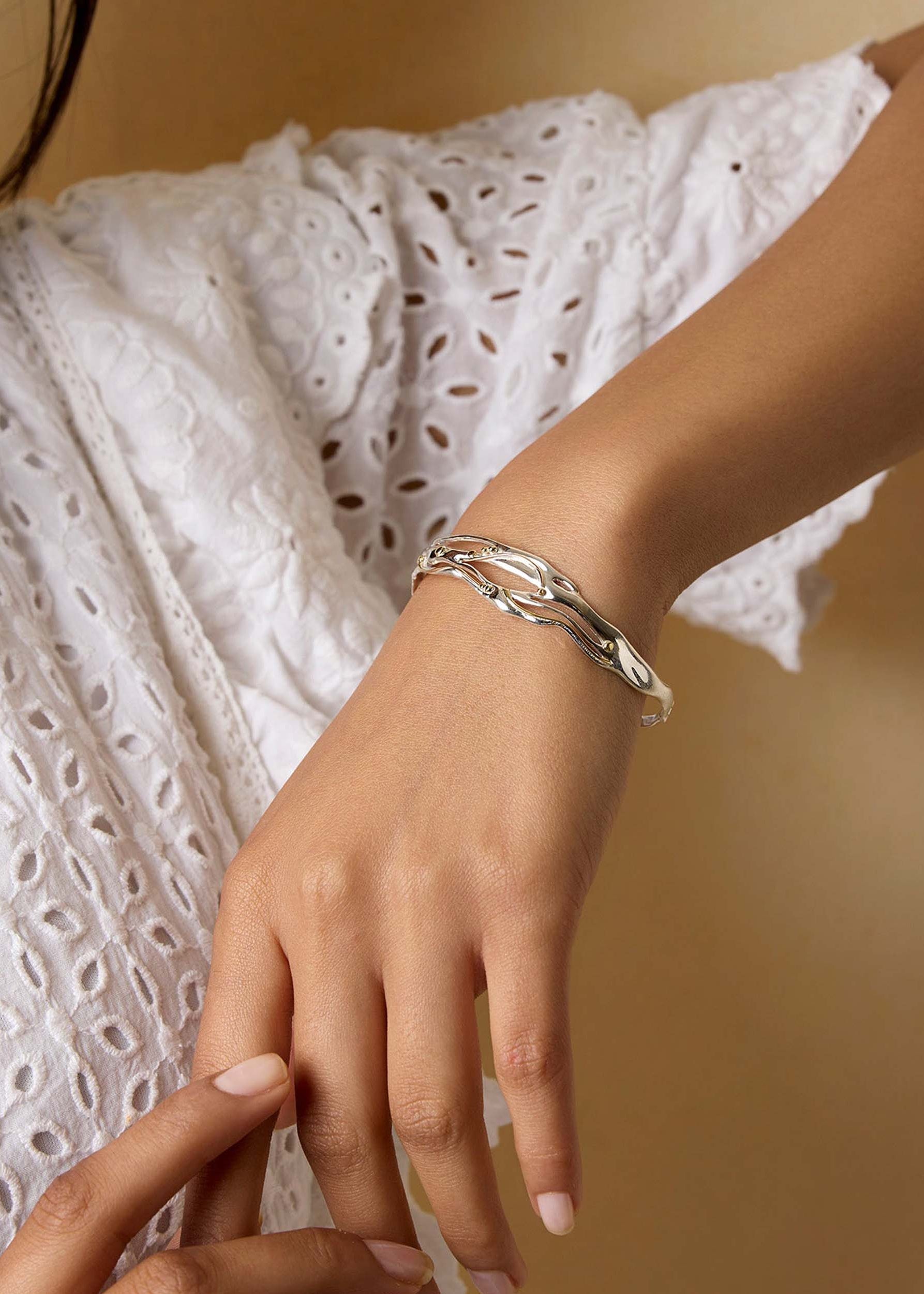 model wearing a silver and gold bracelet