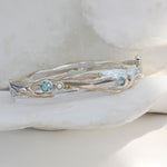 Sterling silver handcrafted bangle with blue topaz and pearl stones