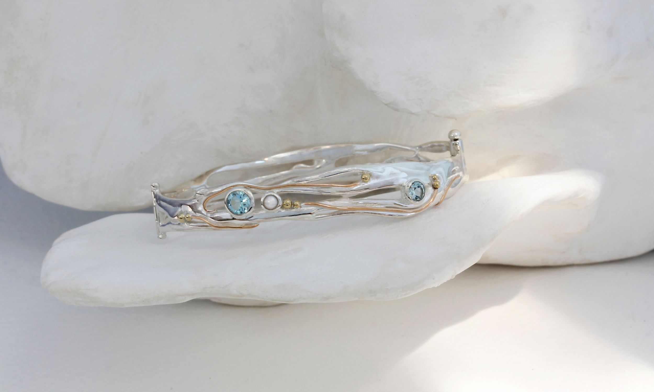 Sterling silver handcrafted bangle with blue topaz and pearl stones