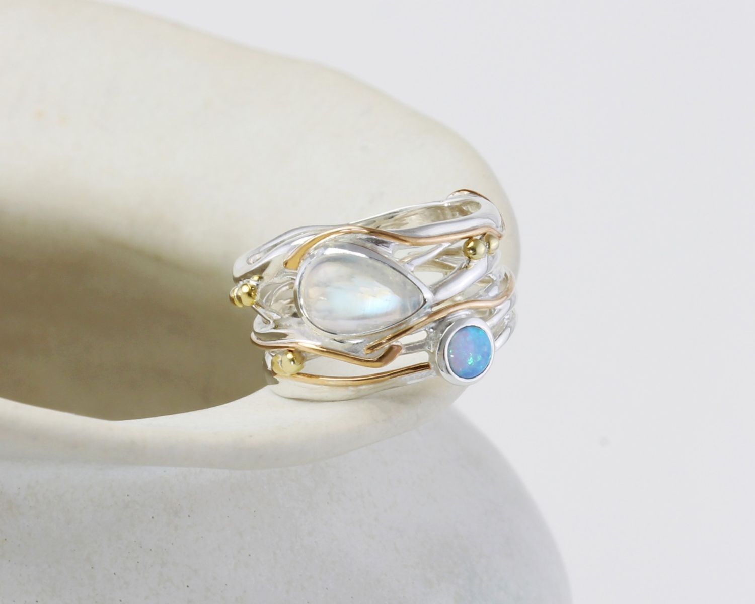 Gold and silver ring with gemstones on a white background
