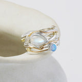 Gold and silver ring with gemstones on a white background