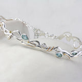 Sterling Silver Bracelet with Blue Topaz and Pearl on a ceramic pot