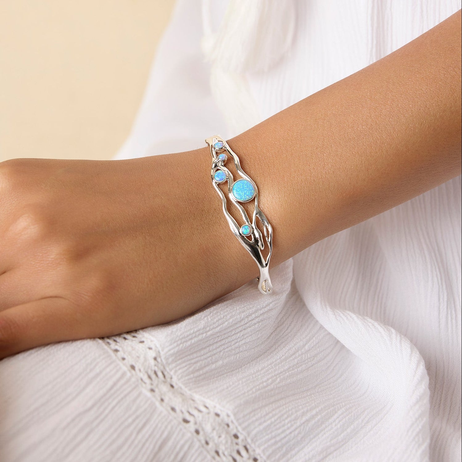 Model wearing silver and blue opal bracelet on their wrist