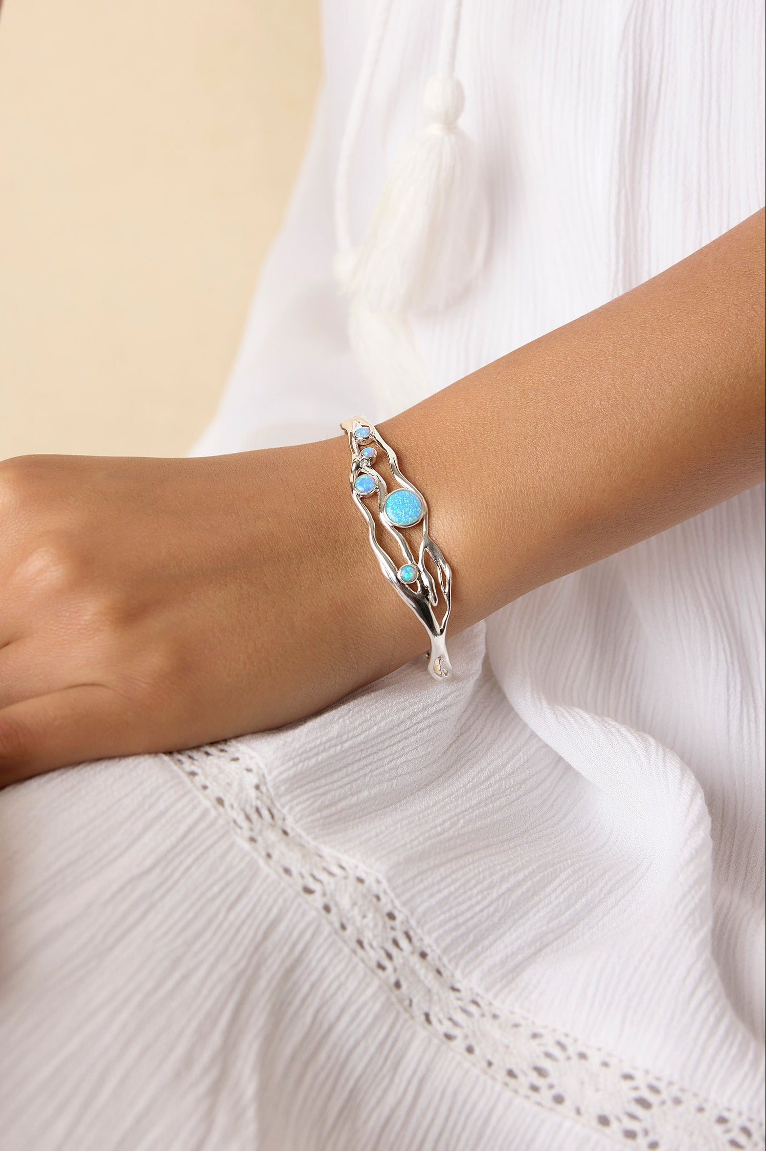Model wearing silver and blue opal bracelet on their wrist
