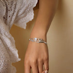 Model leans on wall wearing sterling silver and moonstone bracelet