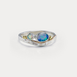 A Sterling Silver ring with a central blue-green Opal and white Opal accents, featuring gold flowing details on a hammered band.